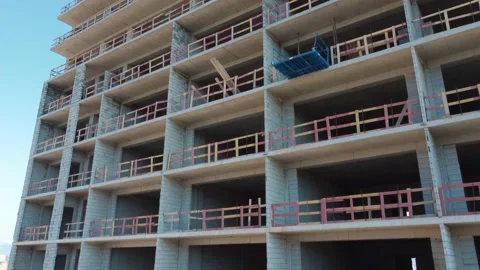 New unfinished tall apartment complex against blue sky, Stock Footage 239253579