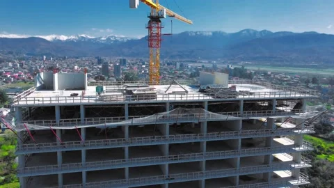 New unfinished tall apartment complex against blue sky, mountains, sea Stock Footage 239254081