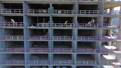 New unfinished tall apartment complex against blue sky, mountains, sea Stock Footage 239254432
