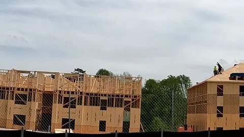 New urban apartment home complex being built and workers on roof street pan Stock Footage 180233269