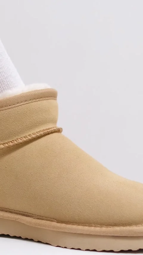 New winter uggs warm leather boots for women beige uggs girl touches hands Stock Footage 305979099