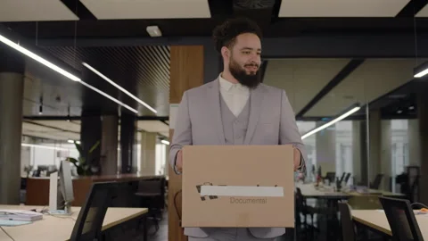 A new worker has just arrived at the office carrying personal belongings in a Stock Footage 305461446