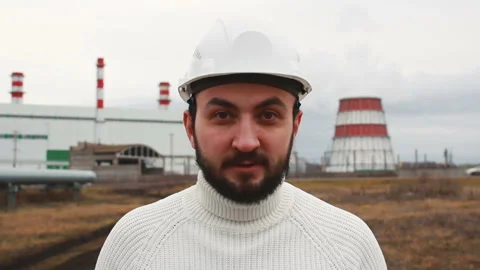 New worker looking at camera against thermal power plant Stock Footage 142859698