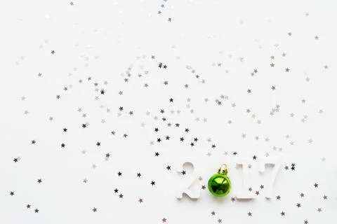 New Year 2017 background with bright green ball and stars confettil Stock Photos