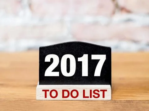 New year 2017 to do list on blackboard sign on wood table at brick wall. Stock Illustration