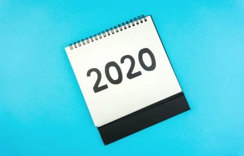 New year 2020 concept: flat lay of desktop calendar isolated on blue Stock Photos