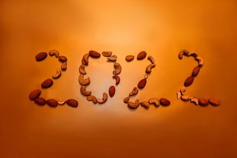New year 2022. Number 2022 is lined with nuts on gold background. Stock Photos
