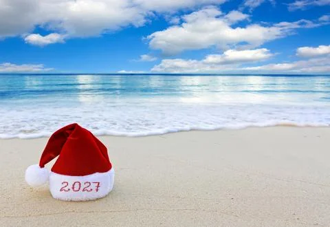 New Year 2027 background with red Santa hat on Caribbean beach. Stock Photos