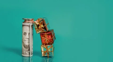 New year balls, bundle of dollar bills with coins and small gift boxes on a Stock Photos