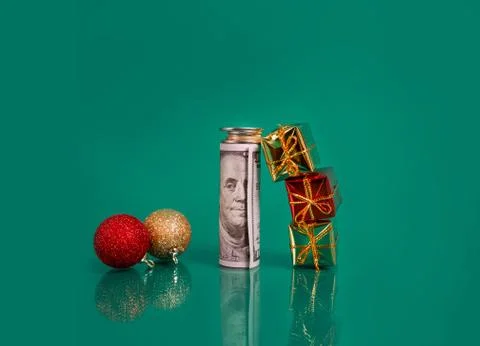 New year balls, bundle of dollar bills with coins and small gift boxes on a Stock Photos