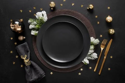 New Year black table setting with elegant golden decorations on black table.. Stock Photos