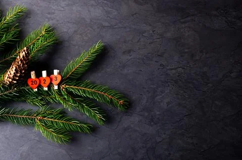 New year composition with pine branches, pine cones and number 2022 on dark h Stock Photos