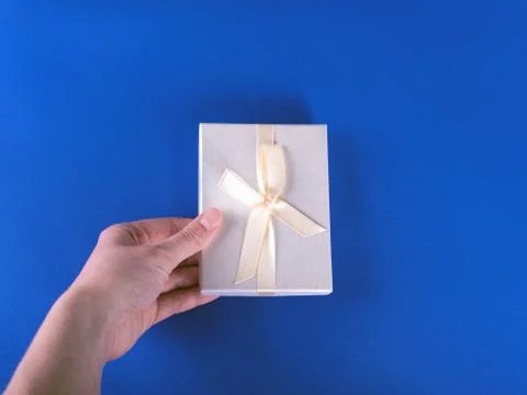 The new year composition of the present with the hand on the blue background. Stock Photos