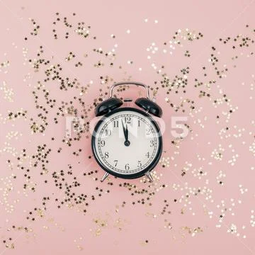 New Year concept. Alarm clock with golden confetti Stock Photos
