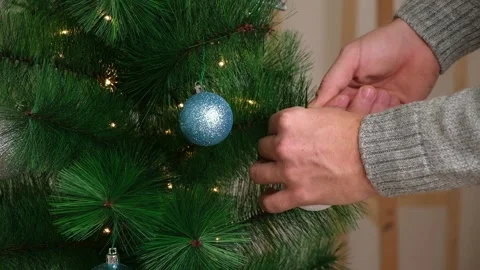 New Year decor. A man decorates a Christmas tree with an electric garland Stock Footage 217416023