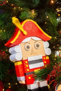 New year festive nutcracker in red clothes on a christmas tree Stock Photos
