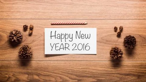 New Year theme background, pine cones and a card on wooden table Stock Photos