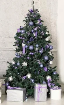 New Year tree decorated with violet and shiny toys Stock Photos