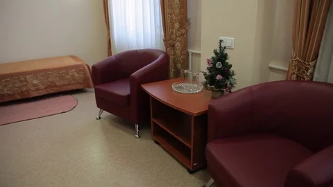 New year tree in a simple hotel room with two armchair Stock Footage 83806006
