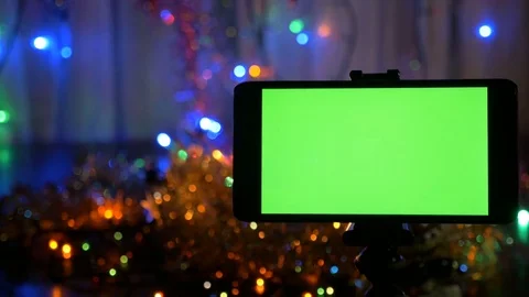 New Year's background, in the foreground a smartphone with a green screen. A Video stock 82498888