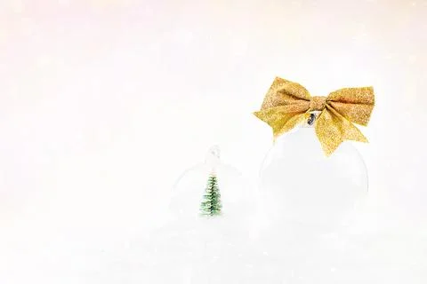 New Year's card background.Close-up.Transparent glass ball with a gold bow lies Stock Photos