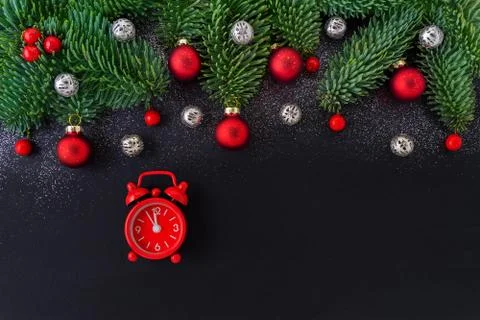 New year's clock on black background with decoration, red berrys, bauble and fir Stock Photos