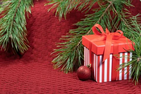 New Year's composition with a pine branch, a red gift box and Christmas decor Stock Photos
