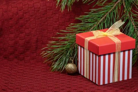New Year's composition with a pine branch, a red gift box and Christmas decor Stock Photos