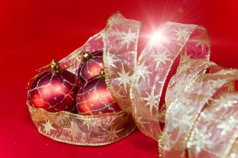 New Year's composition on a red background - ball and ribbon Stock Photos