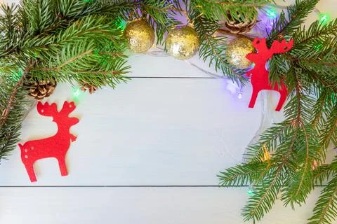 A New Years composition with spruce branches, cones, golden balls, red figures Stock Photos