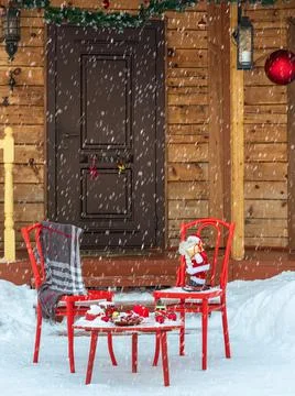 New Year's decorations with a red table and chairs in front of the house entr Stock Photos