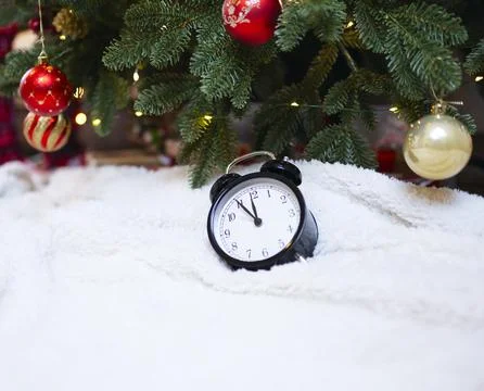 New Year's eve background with a clock under a Christmas tree decorated with Stock Photos
