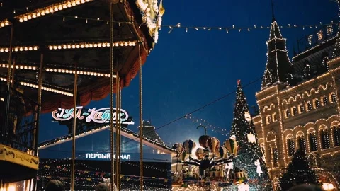 New Year's evening atmosphere on Red Square, GUM, Moscow, carousel, falling snow Stock Footage 211330771