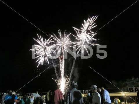 New Years Fireworks burst in the air as people watch display at Outdoor New Y Stock Photos