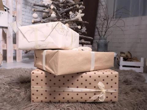 New Year's gift in boxes of light tones on a soft brown carpet. Stockfoto's