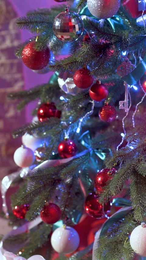 New Year's gifts in red boxes with ribbons near the Christmas tree Stock Footage 290764342