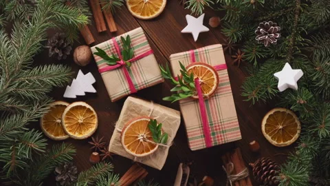 New Year's gifts wrapped in craft paper on a wooden background, rotation, top Stock Footage 144071153