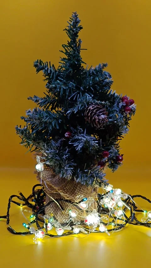 New Year's lights and a beautiful Christmas tree decoration on a bright yellow b Stock-Footage 322676853
