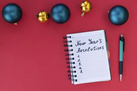 New Year's resolutions on red background with Christmas balls. New Year's res Stock Photos