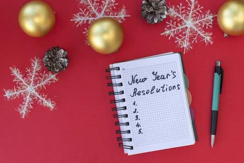 New Year's resolutions on red background with snowflakes, Christmas balls, an Stock Photos