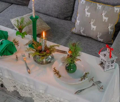 New Year's table setting with linen tablecloth, candles and spruce branches Stock Photos