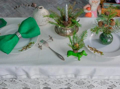 New Year's table setting with linen tablecloth, candles and spruce branches Stock Photos