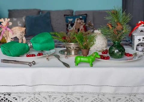New Year's table setting with linen tablecloth, candles and spruce branches Stock Photos