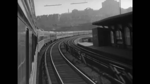 NEW YORK - 1949 - Steam train pulling passenger cars speeds along track near the Stock-Footage 296693379