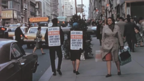 New York - 1965: Couple of workers walk the street protesting against employer Stock Footage 283393348