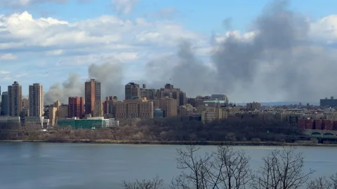 New York City Fire causes dark smoke rise over buildings - 4K Prores 422 HQ Stock Footage 234839261