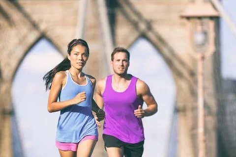 New York city runners running training for marathon on Brooklyn bridge NYC in Stock Photos