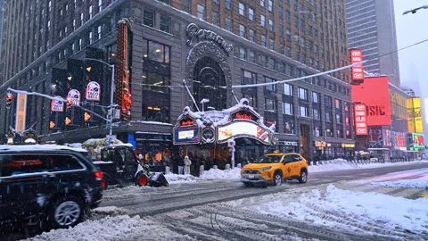 New York streets during the heavy snowstorm. Vehicles and people work to clean Stock Footage 329636475