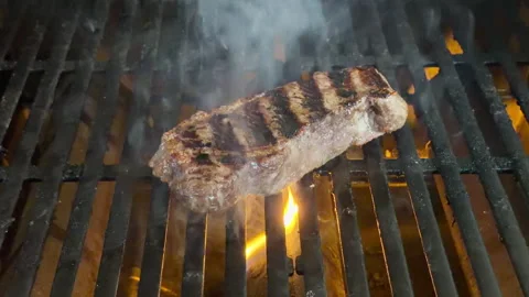 New York Strip steak turned on grill causing flare-up of flames and smoke. Stock Footage 339355380