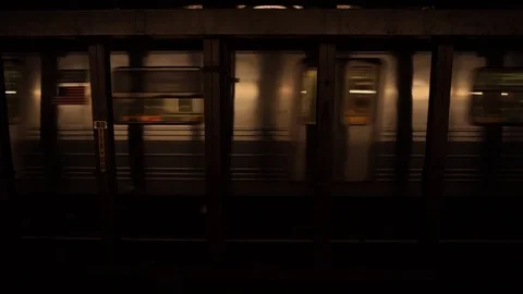 A New York subway train passing through a subway station Stock Footage